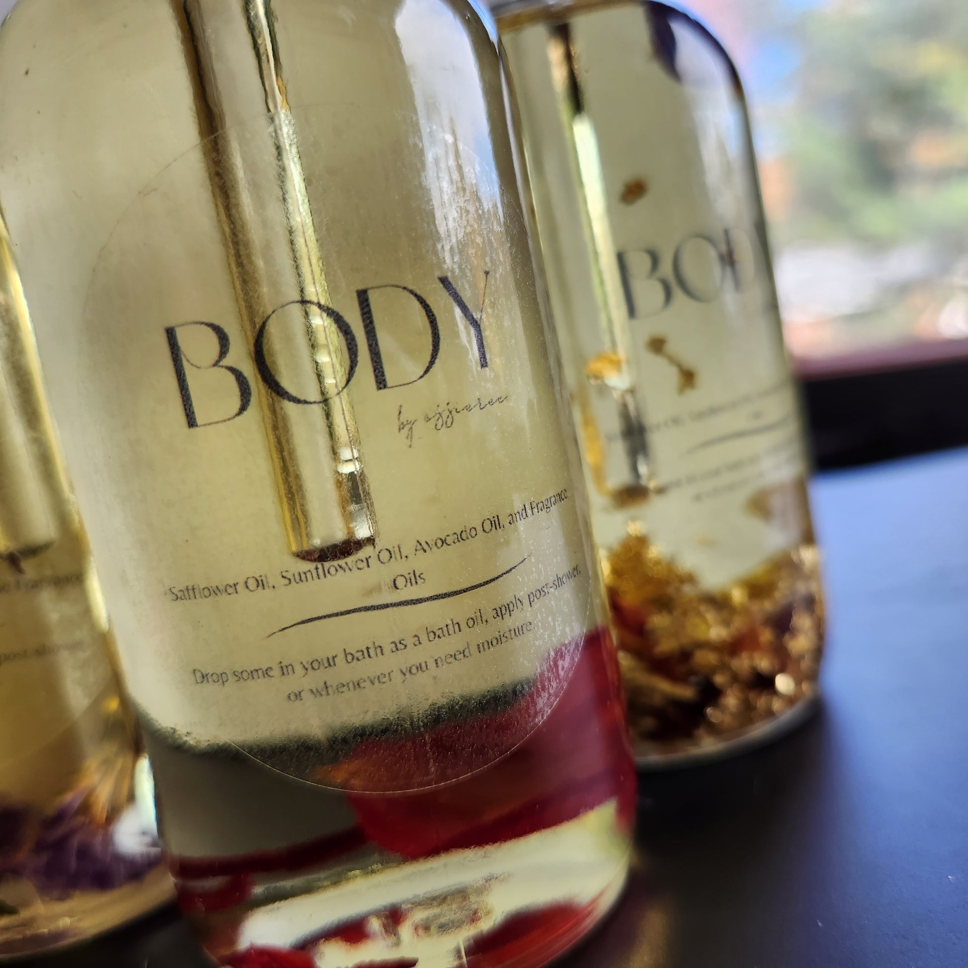 Close shot of fragranced body oil in a dropper bottle showing ingredients